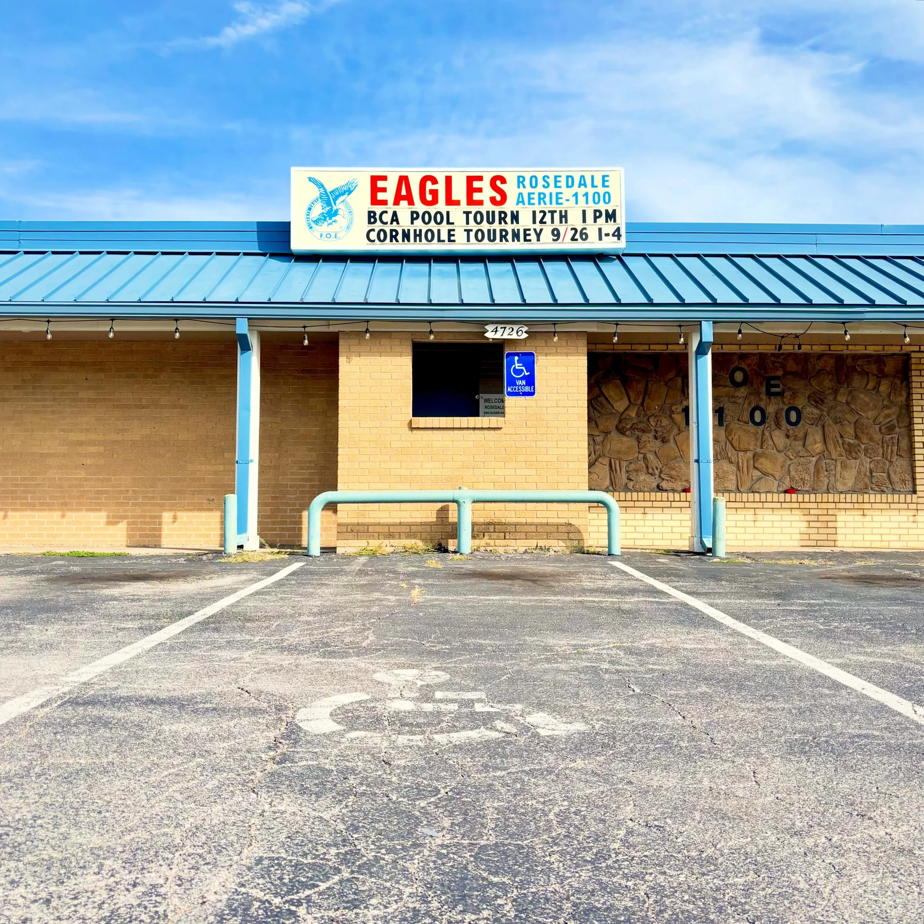 The Eagles building with a blue roof and bright sky.