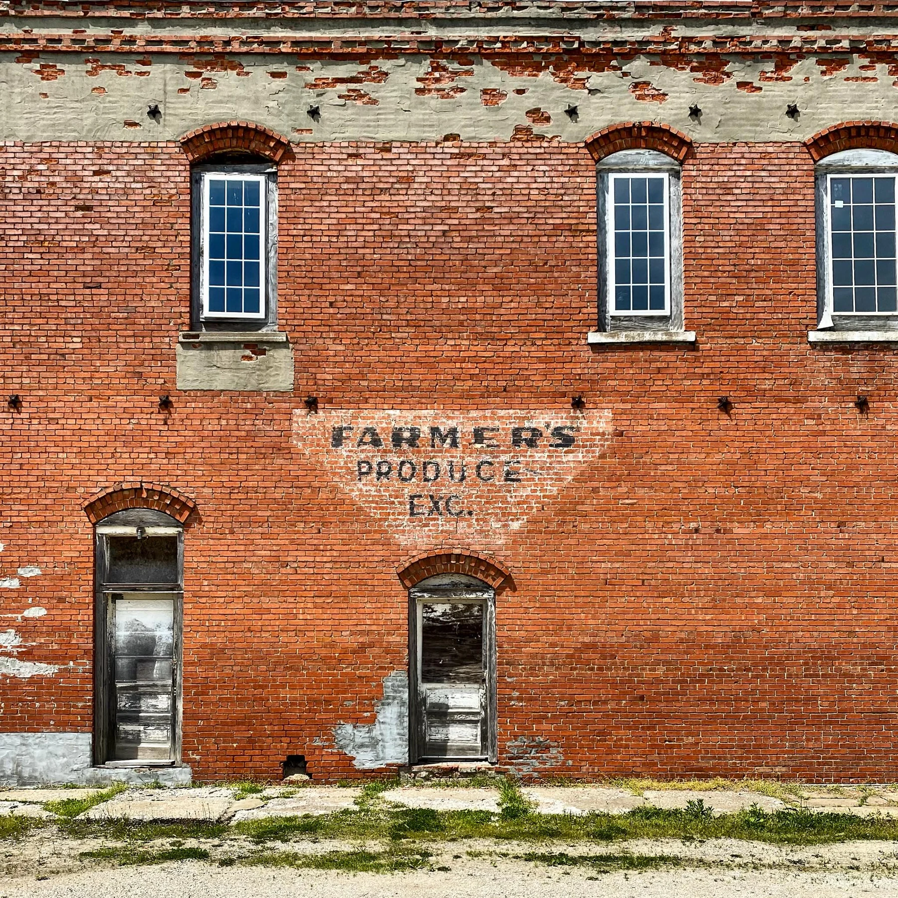 A weathered red brick Farmers Produce building.